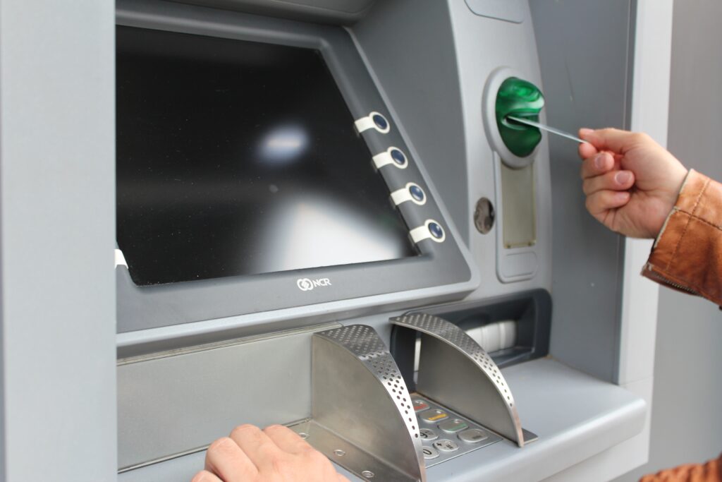 An image of a man inserting a card into an ATM machine