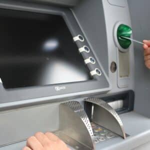 An image of a man inserting a card into an ATM machine