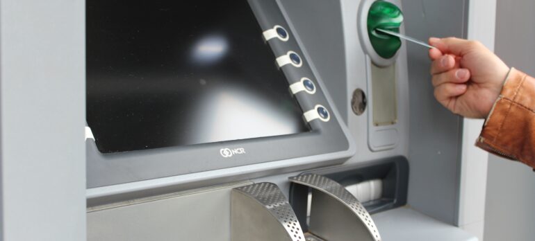 An image of a man inserting a card into an ATM machine